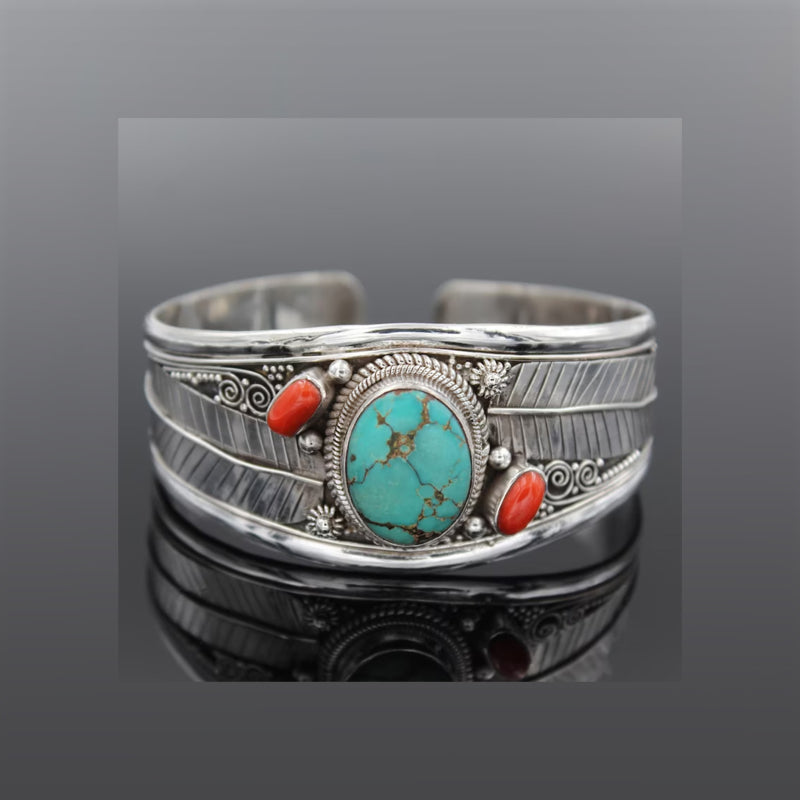 Turquoise and coral feather cuff bracelet in silver with intricate detailing.