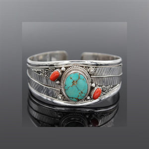 Turquoise and coral feather cuff bracelet in silver with intricate detailing.