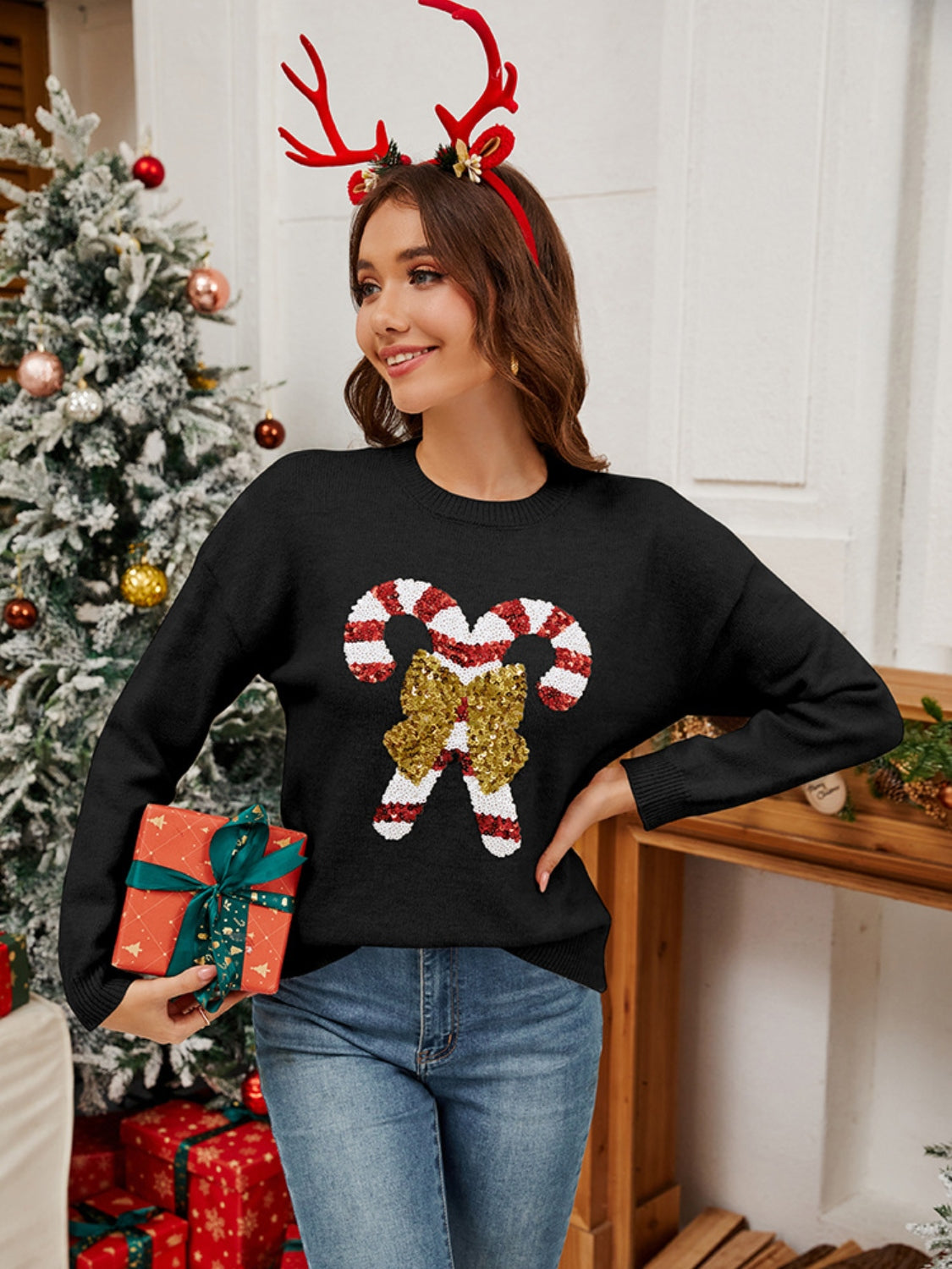 Black acrylic sweater with sequin candy cane and bow detail, crew neck, long sleeves.