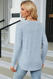 Light blue long sleeve sweater with side button slit hem detail