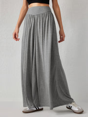 Grey jersey wide-leg trousers with a draped V-waistband and flowy silhouette.