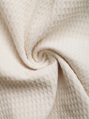 Beige waffle knit fabric detail of a romper