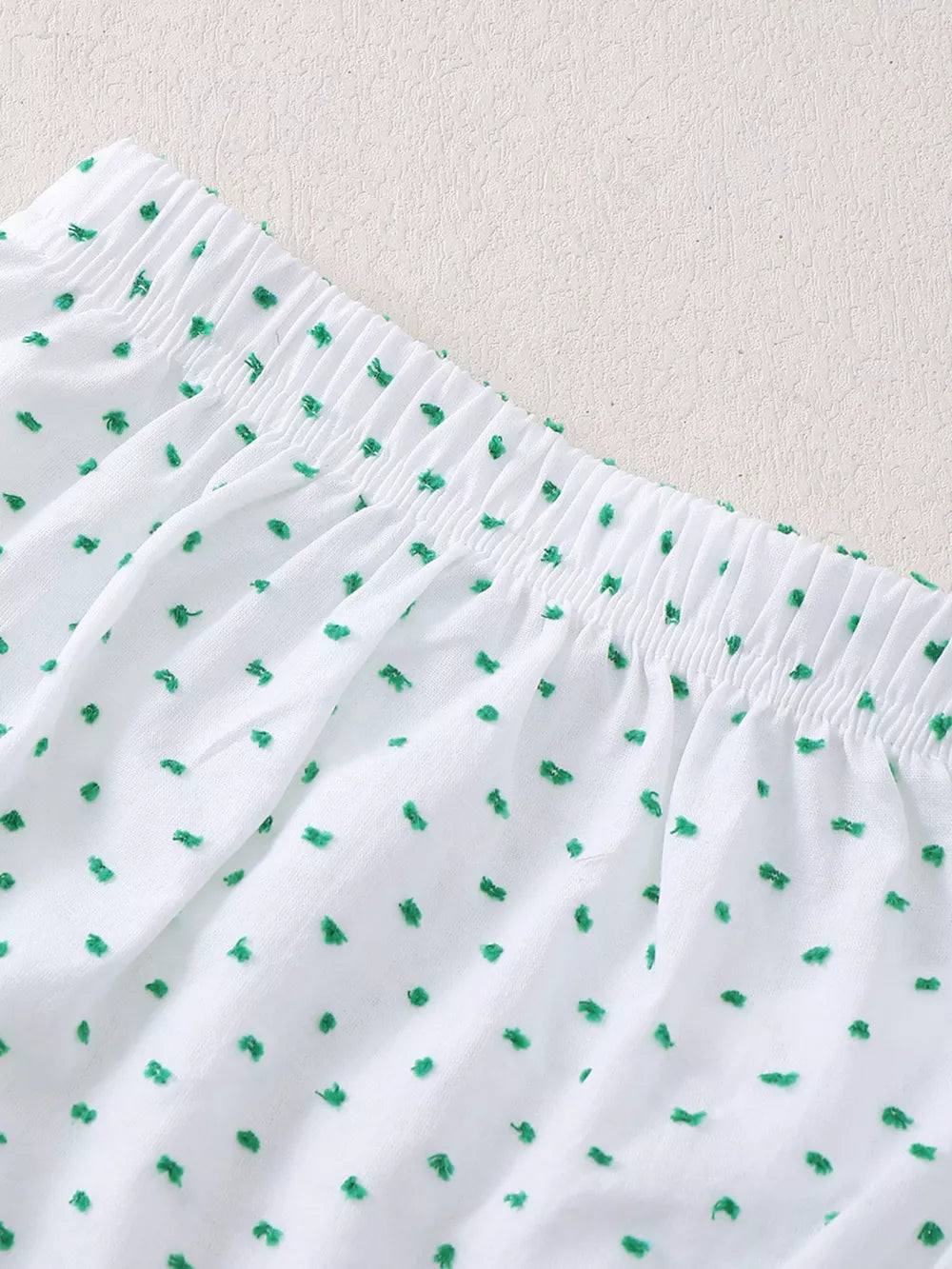 White baby set with green embroidered dots and elastic waistband