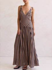 Tie-shoulder maxi dress with V-neck in brown and navy stripes, featuring adjustable straps and a flowing skirt.