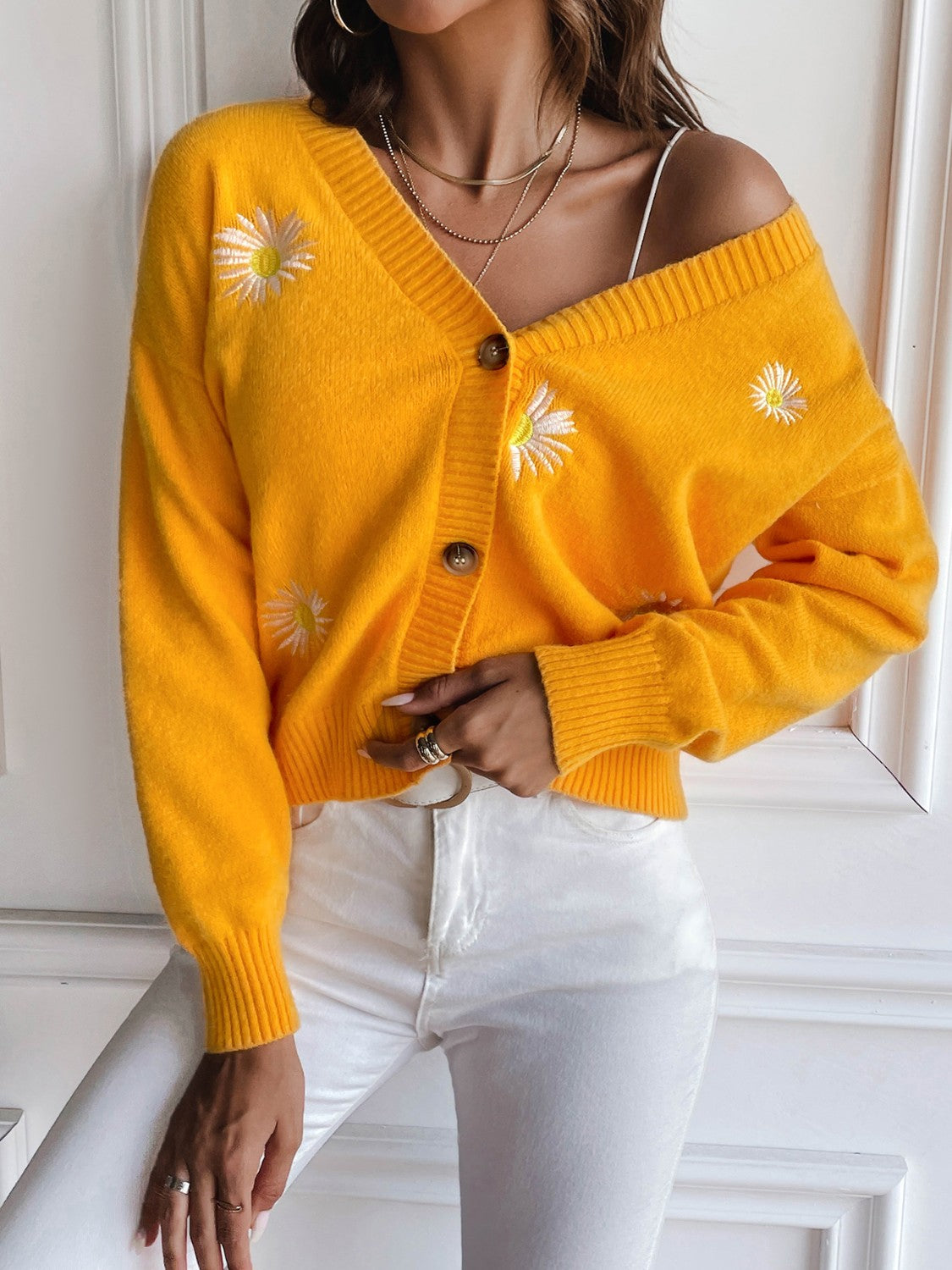 Gold button-down cardigan with daisy embroidery and V-neck.