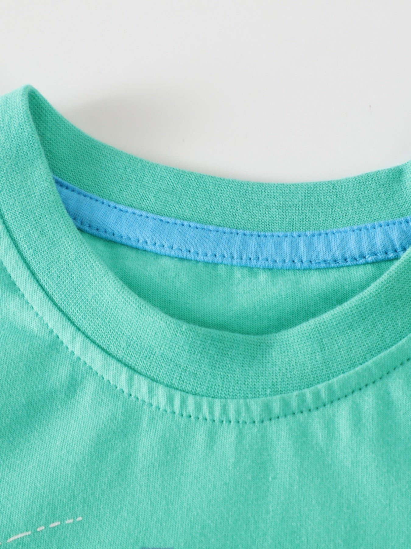 Green cotton toddler t-shirt with blue trim detail at the neckline.