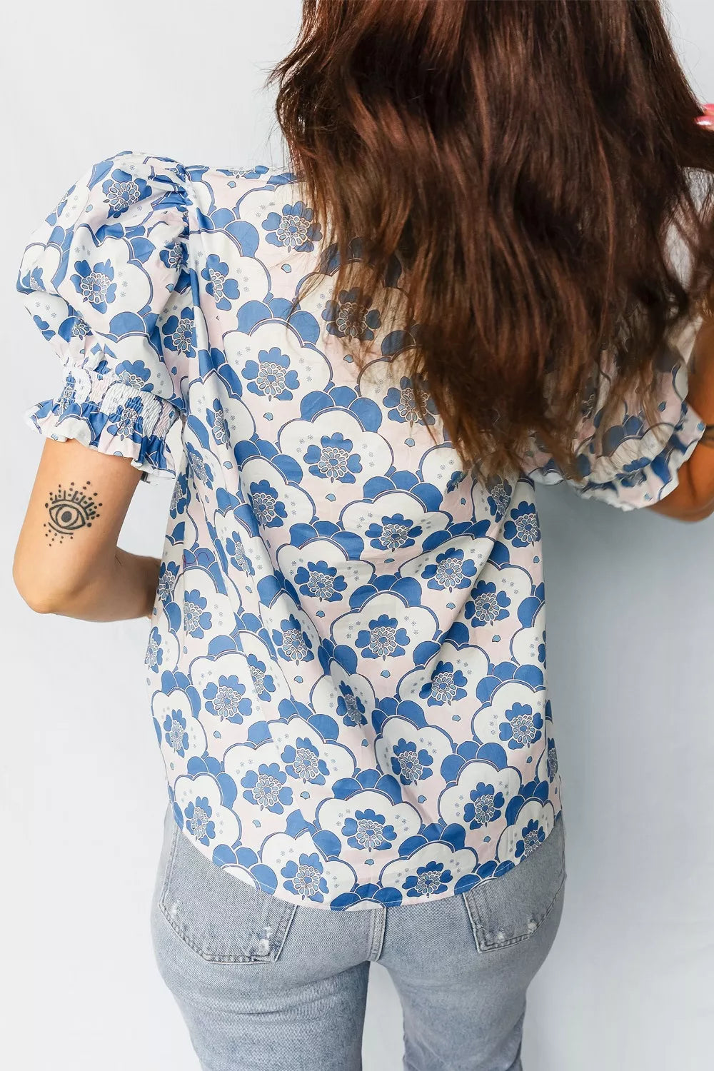 Playful Floral Puff Sleeve Shirt with blue and white floral print, smocked cuffs, and frill detail.