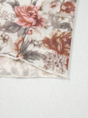 Charming floral mesh blouse with ruffled hem detail.