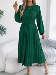 Green midi dress with long sleeves, ruffled neckline, smocked waist, and pleated skirt.