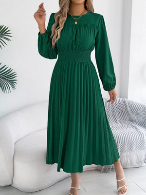 Green midi dress with long sleeves, ruffled neckline, smocked waist, and pleated skirt.