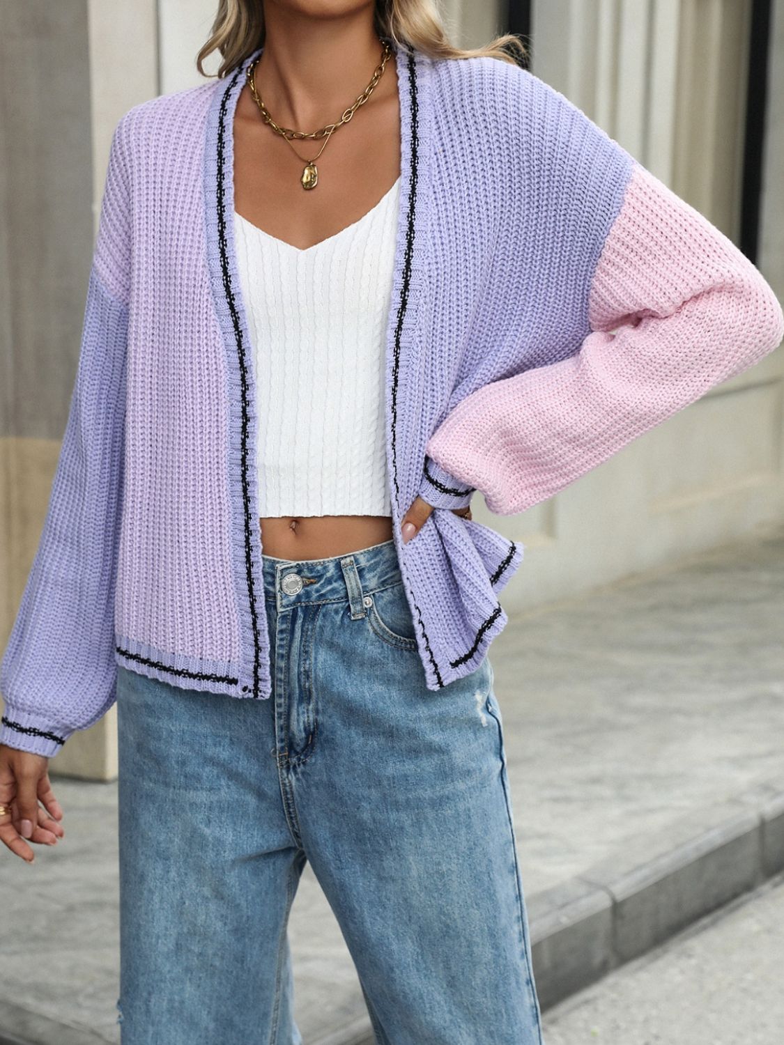 Colorblock trim knit cardigan in pink and purple acrylic with black trim.