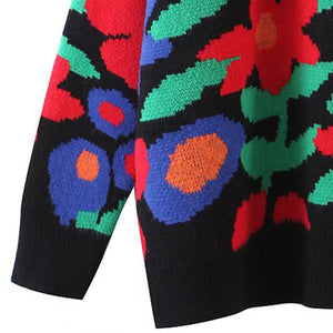 Black acrylic crewneck knit sweater with a bold floral intarsia pattern in red, blue, green, and orange.