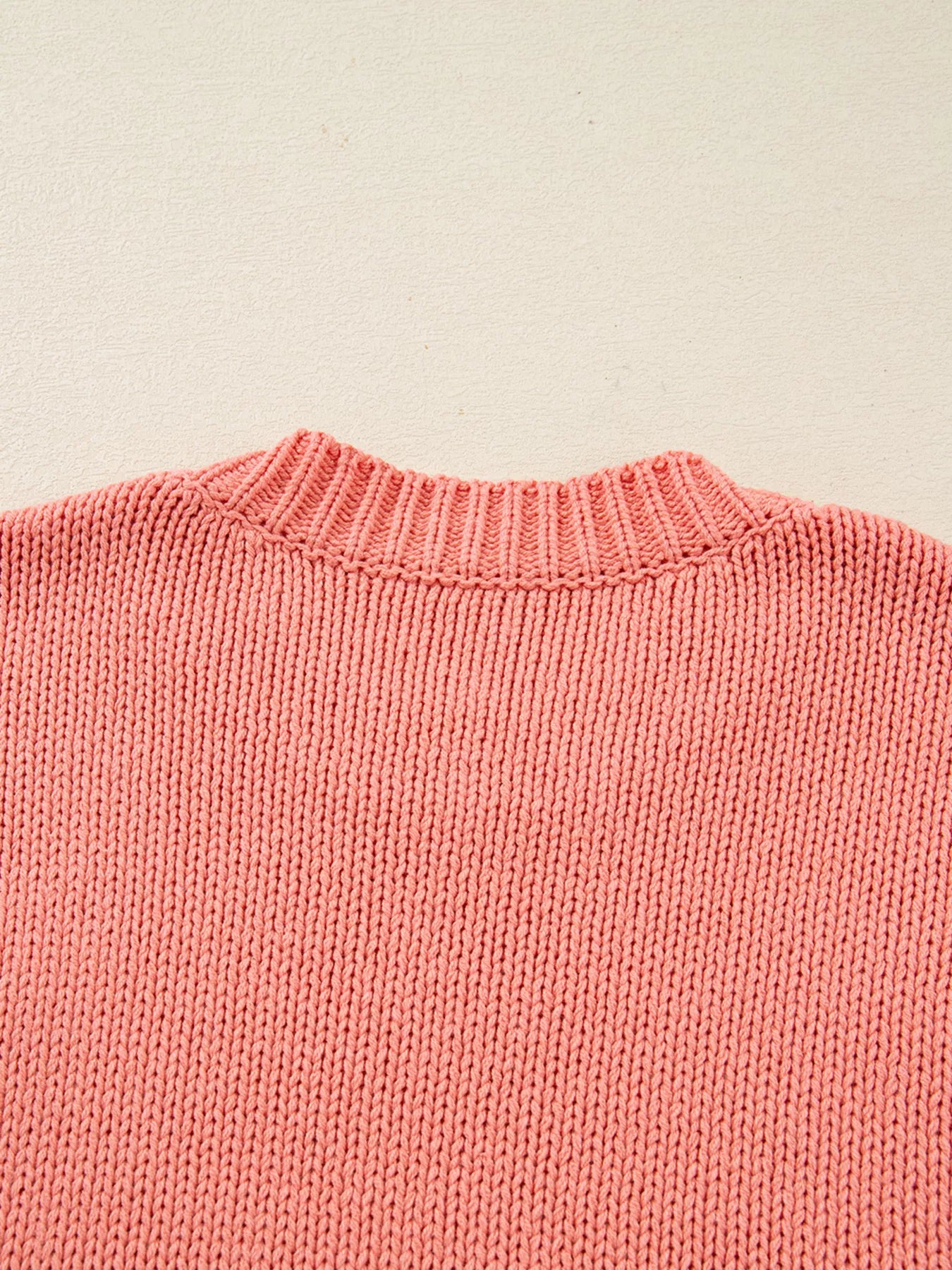 Burnt coral knit sweater with ribbed crewneck and textured stitch detail.