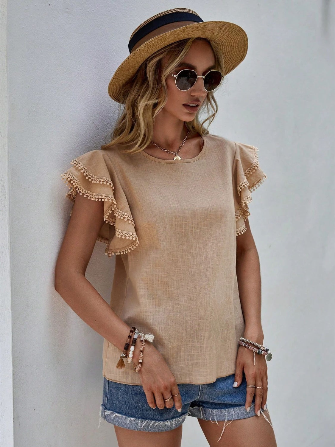 Khaki linen blend top with pom-pom trimmed ruffle sleeves and round neckline.