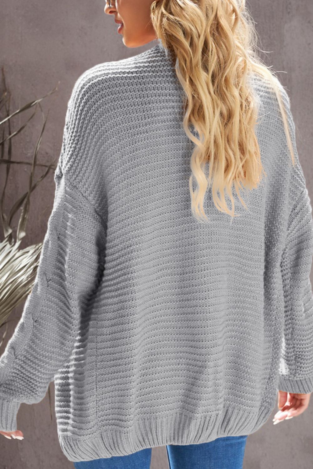 Gray cable knit open-front cocoon cardigan with ribbed texture and balloon sleeves.