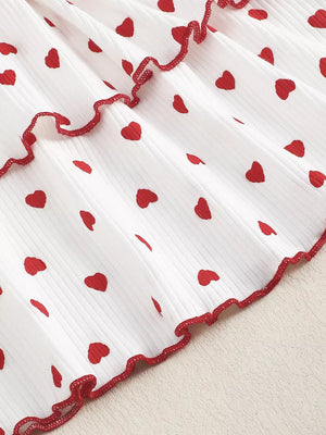White tiered baby dress with red hearts and ruffled trim.