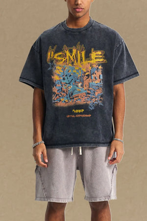 Washed black oversized graphic t-shirt with yellow "SMILE" text and abstract art print.