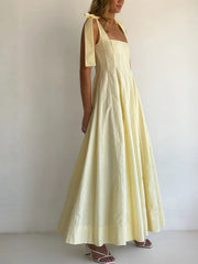 Yellow maxi dress with square neckline and bow-tie shoulder straps