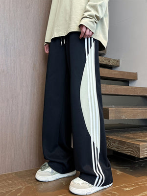 Men's black wide leg casual trousers with side stripe detail and drawstring.