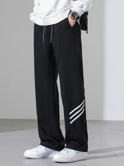 Black sweatpants with white side stripes and a drawstring waist.