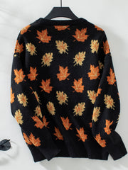 Black knit jumper with orange and yellow autumnal leaf pattern, crew neck, long sleeves.