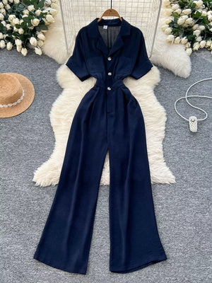 Navy belted wide-leg maternity jumpsuit with pockets and button front.
