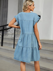 Light blue denim trapeze mini dress with ruffled short sleeves and tiered skirt.