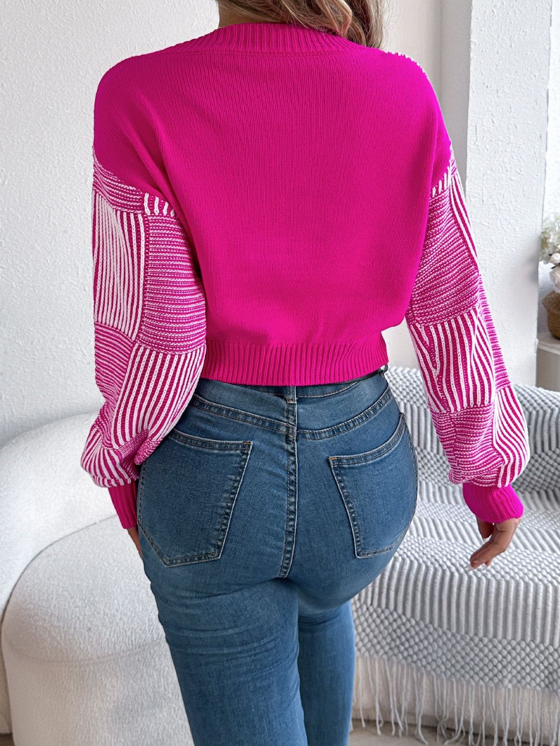 Hot pink cropped knit sweater with geometric stripe sleeves and V-neck