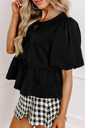 Black peplum blouse with puff sleeves and bow detail, peplum hem