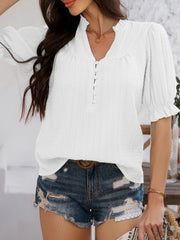 White textured puff sleeve blouse with button detail and ruffled cuffs.