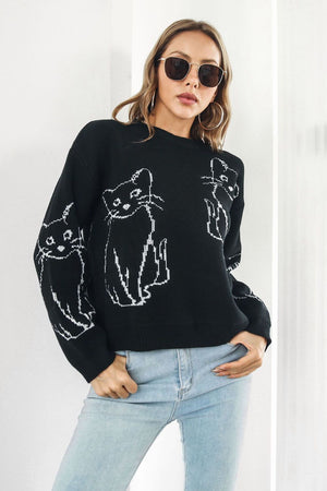Black acrylic sweater with white cat intarsia motif, crew neck, long sleeves.