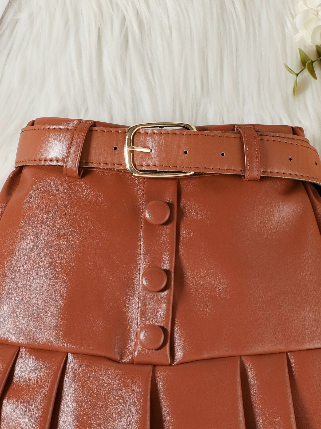 Brown toddler skirt with pleats, button front, and faux leather belt with gold buckle.