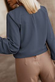Misty Blue pleated yoke blouse with button detail and gathered sleeves.