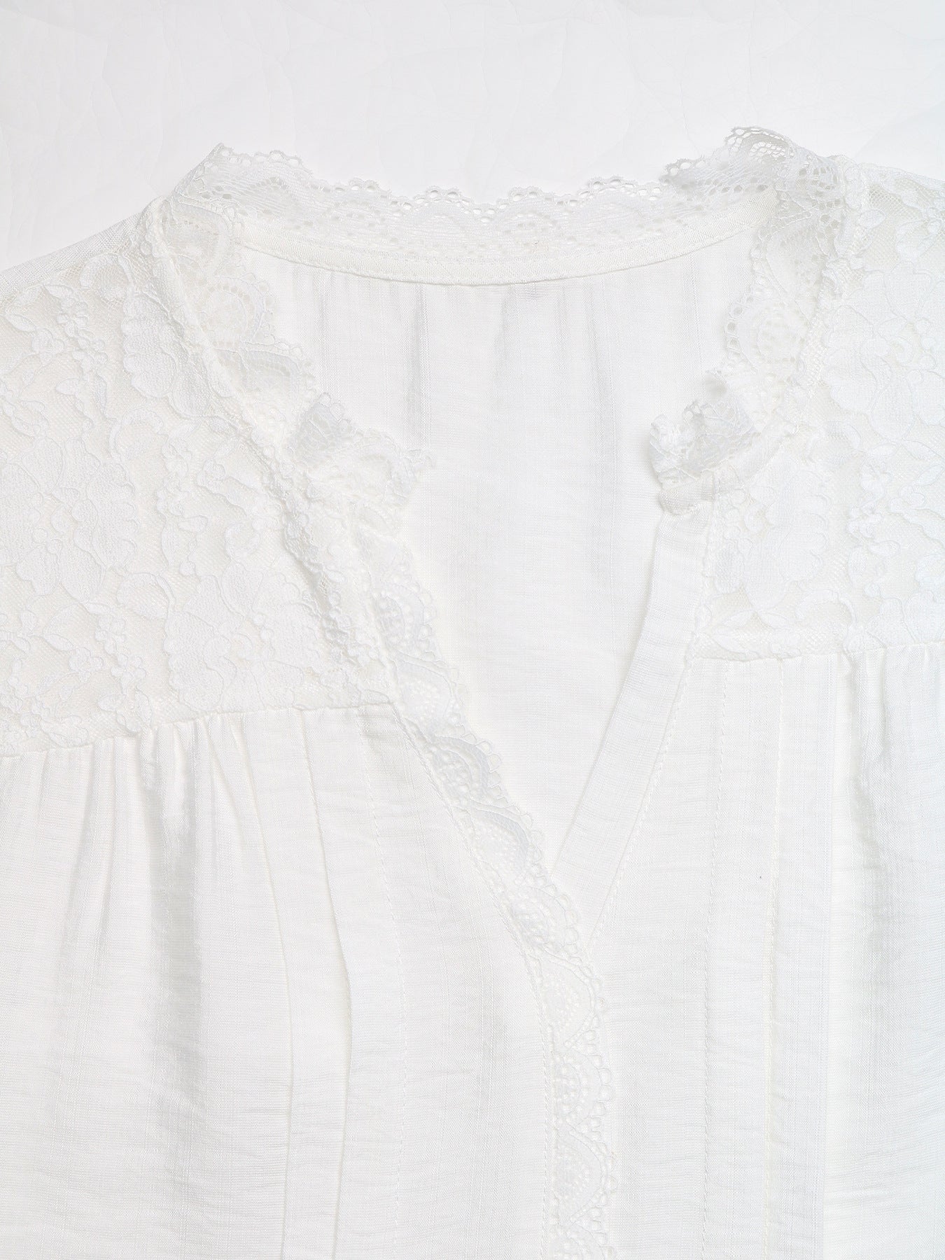 White lace-trimmed V-neck maternity blouse with delicate fabric details
