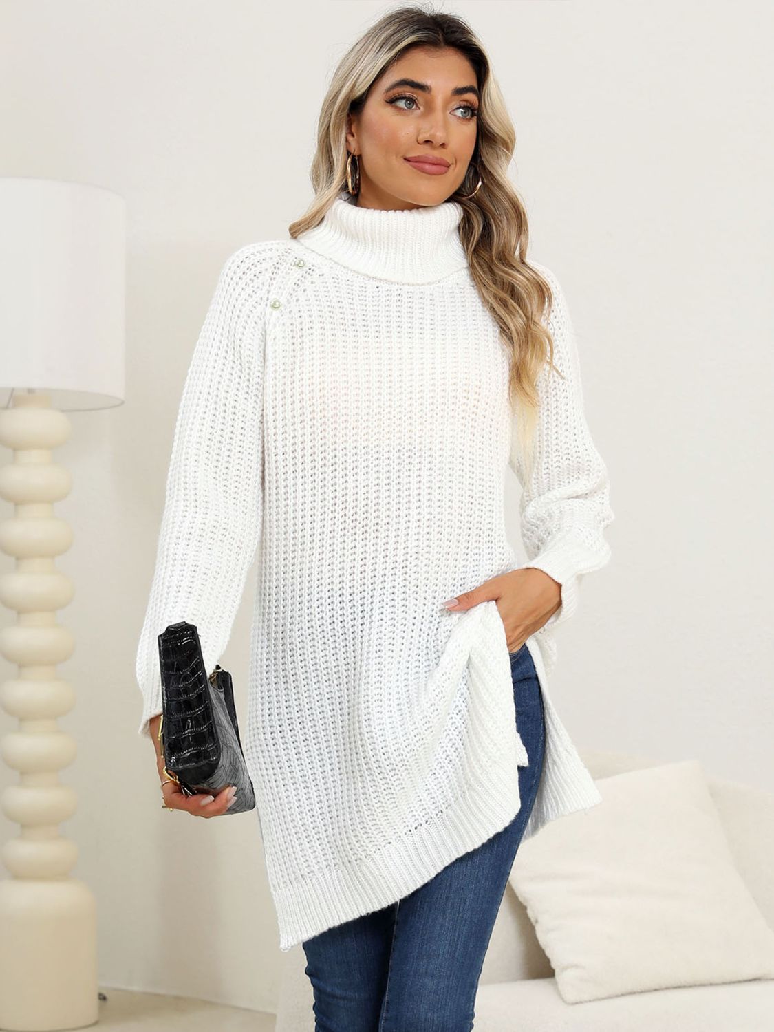 White ribbed turtleneck tunic with pearl embellishments on the shoulder, side slits, and a cozy knit.