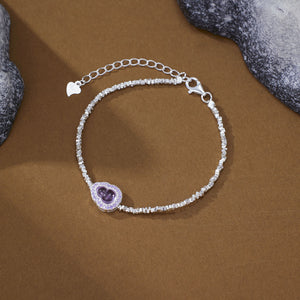 Delicate silver charm bracelet with purple gourd charm and crystal accents.