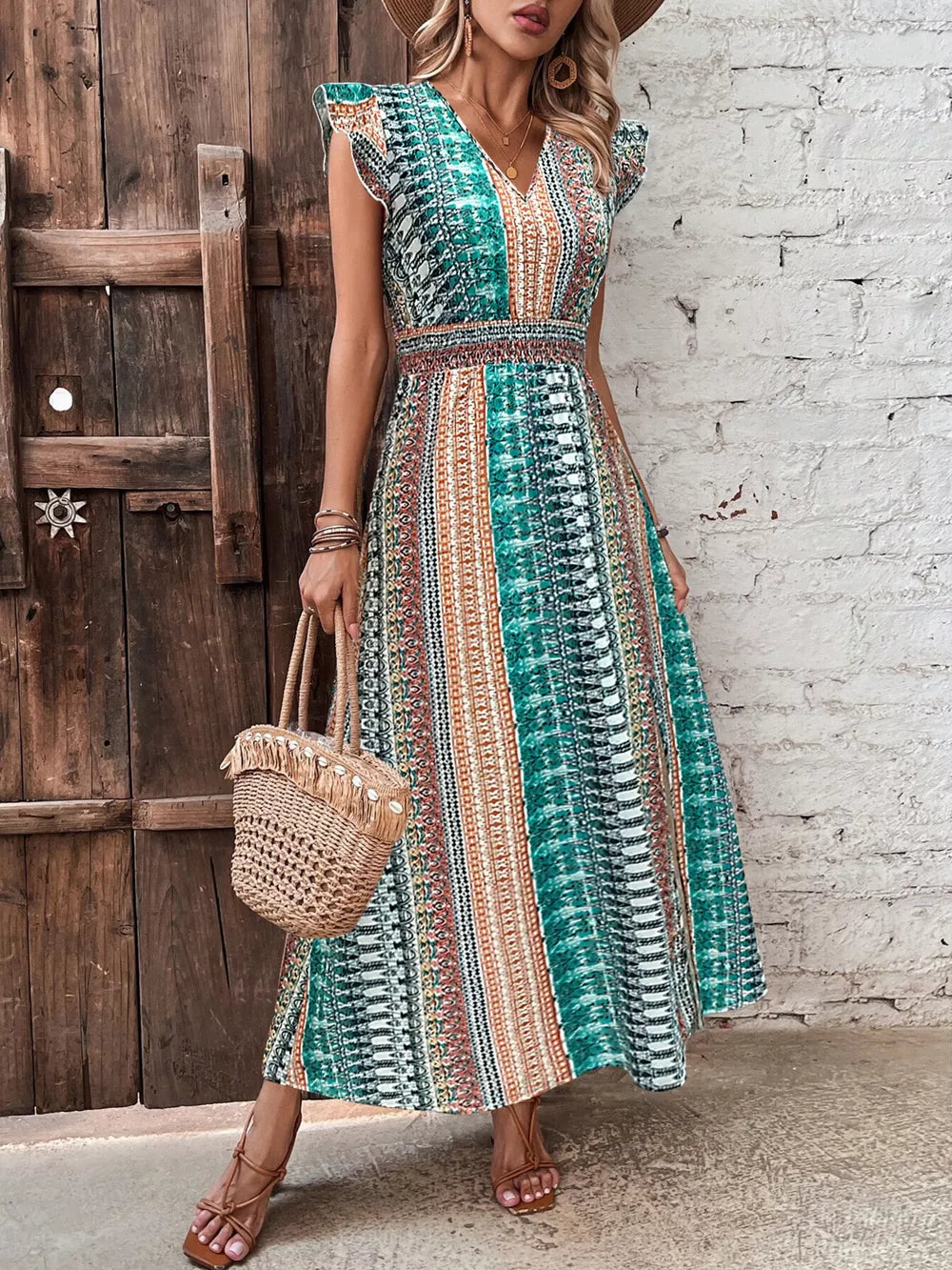 Bohemian maxi dress with ruffle sleeves, V-neck, and smocked waist in a colorful geometric print.