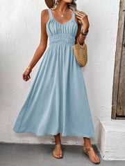 Light blue V-neck smocked midi dress with a textured fabric and spaghetti straps.
