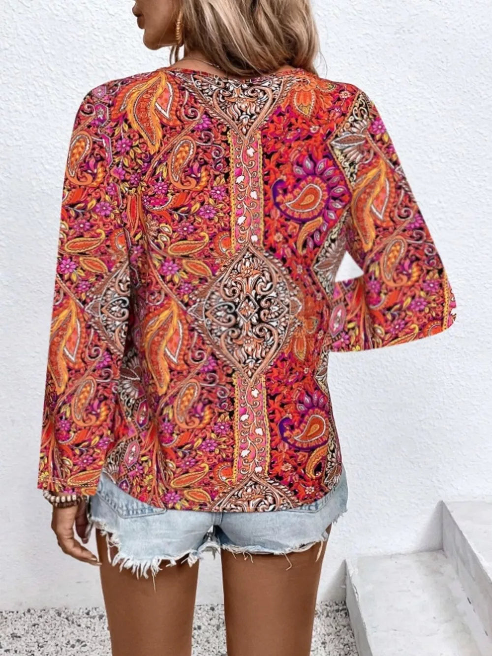 Bohemian paisley v-neck shirt in multicolor with long sleeves, styled with denim shorts.
