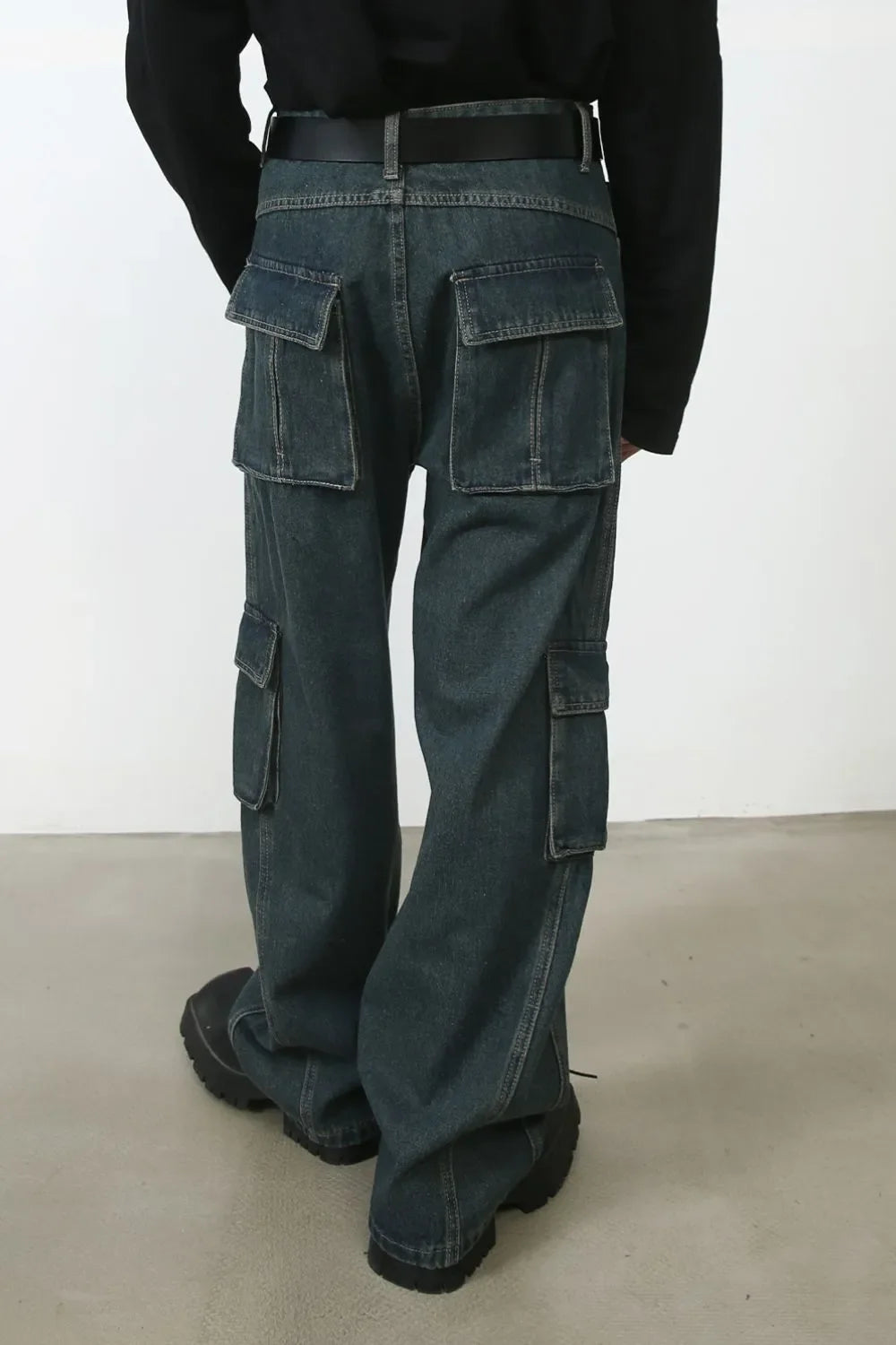Dark denim cargo pants with multiple pockets and a relaxed fit.