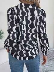Black abstract wave print silk-touch blouse with puff sleeves and button cuffs.