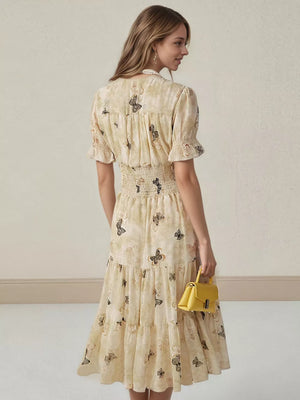 Beige butterfly print midi dress with smocked waist, ruffled sleeves, and tiered skirt.