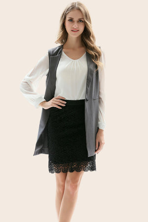 Mid gray tailored sleeveless vest with single button closure, worn over a white blouse and black lace skirt.