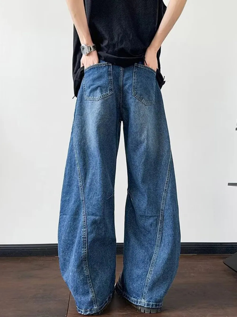 Distressed dark blue wide-leg jeans with a casual, oversized fit.