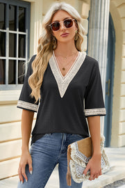 Black textured v-neck top with lace trim on neckline and sleeves.