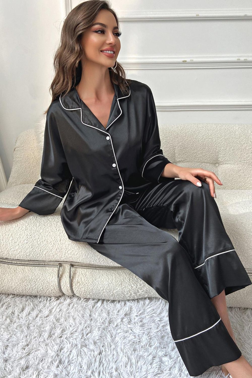 Black satin pajama set with contrast white piping, long sleeves, and button front.