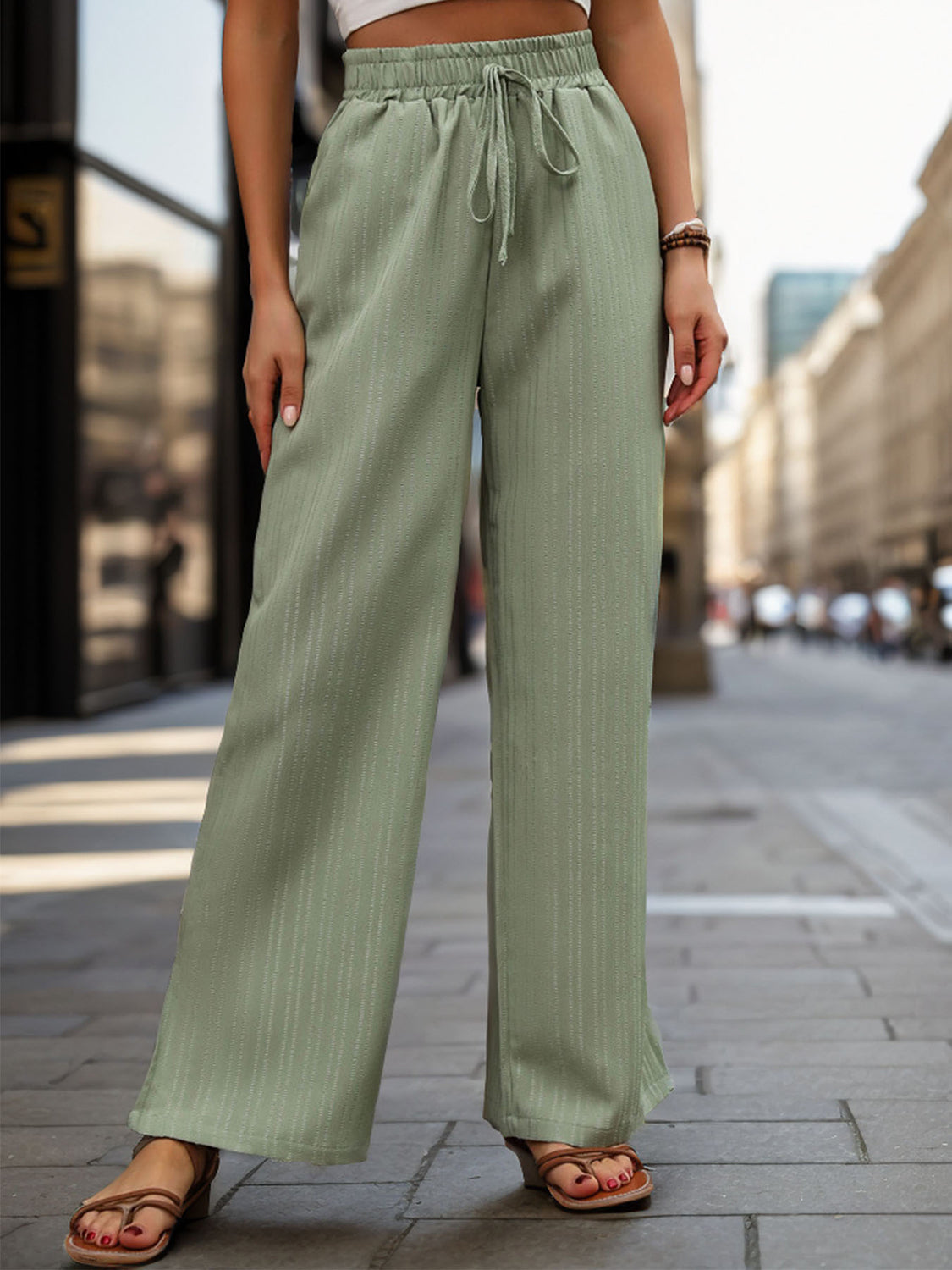 Sage linen blend palazzo trousers with drawstring waist and vertical pinstripe detail.