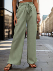 Sage linen blend palazzo trousers with drawstring waist and vertical pinstripe detail.