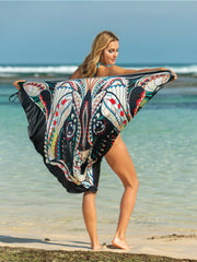 Owl graphic pareo wrap in multicolor with black trim, shown on a beach.