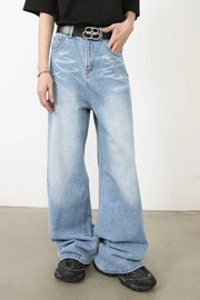 Oversized medium wash denim jeans with distressed details and a wide leg.